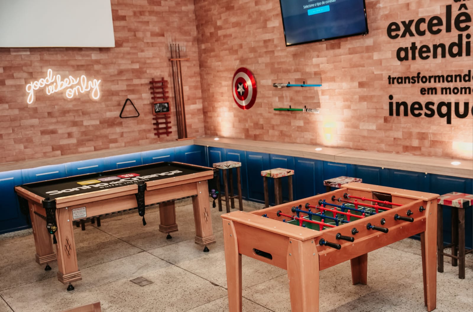 Área de jogos com pebolim e mesa de sinuca